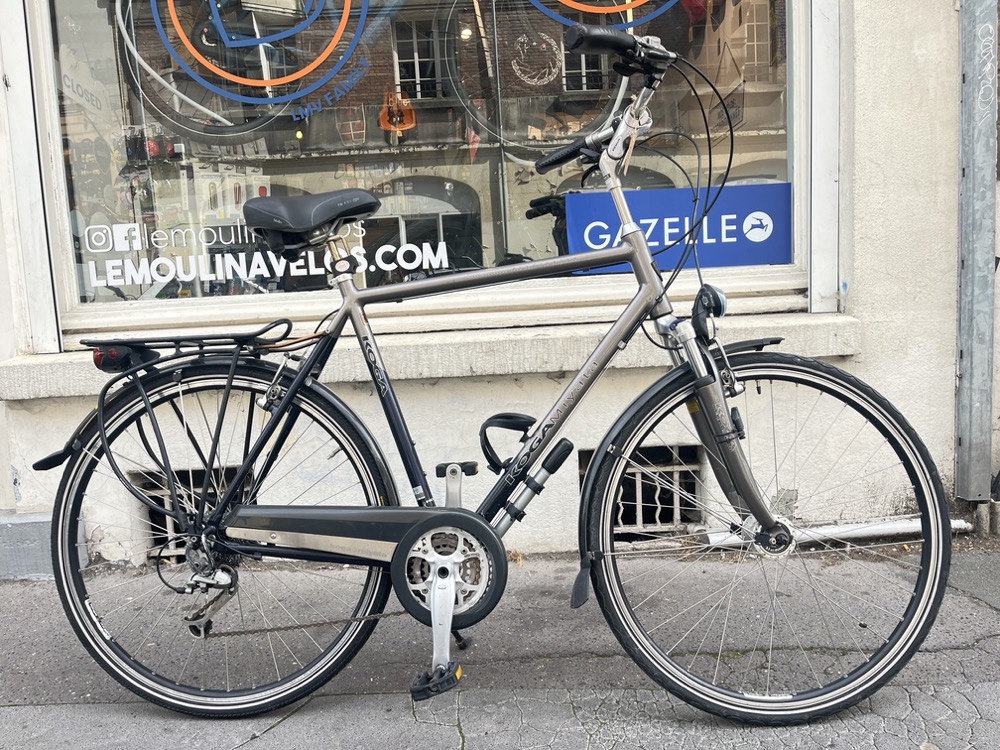 Vélo reconditionné photographié devant la vitrine du Moulin à Vélos